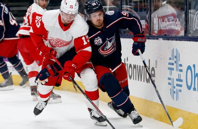 Detroit Red Wings forward Jakub Vrana, left, controls the puck in front of Columbus Blue Jackets forward Jack Roslovic during the first period of an NHL hockey game on Saturday, May 8, 2021.