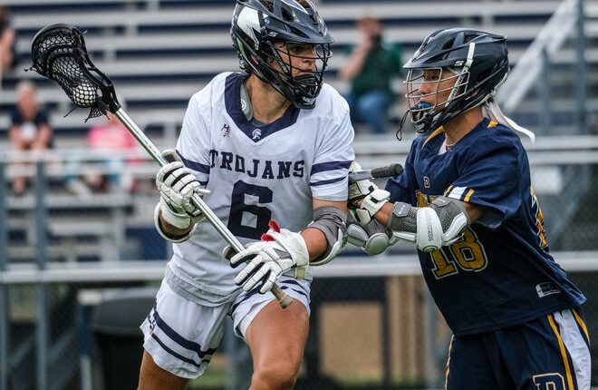 East Lansing senior Marcus Haynie (6) looks to score as Johna Boillat (18) from DeWitt tries to stop him in regional playoff action Friday, May 20, 2022. East Lansing won handily 19-8.