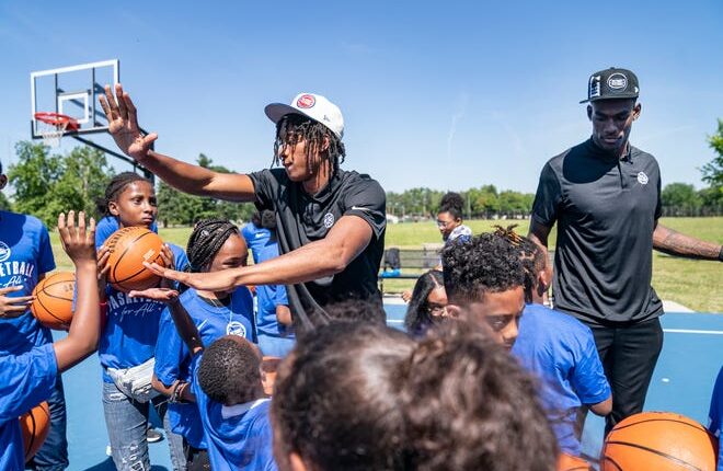 Jaden Ivey, left, high fives members of the Boys and Girls Club as Jalen Duren stands at right after the Detroit Pistons introduce them as new draft picks Friday, June 24, 2022 at Rouge Park in Detroit.
