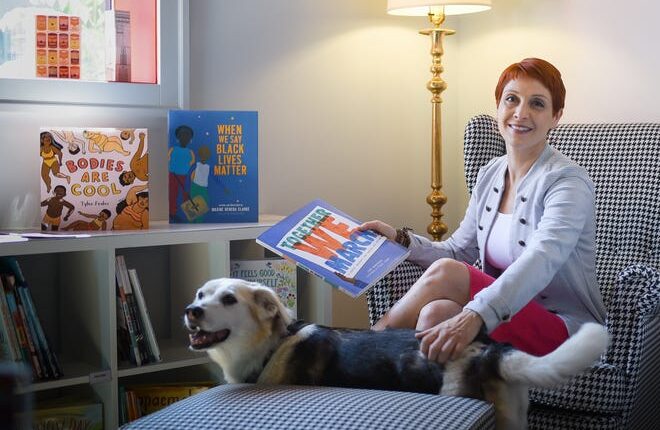 Emily Dievendorf of Lansing pictured with her dog Bijou, Thursday, June 30, 2022, in her Lansing bookstore The Resistance.