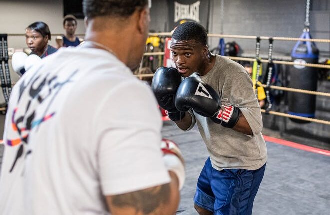 Coach Khalil Harvey Sr., left, practices with Deion Plummer at the SuperBad Boxing Gym in Detroit on Thursday, June 2, 2022.