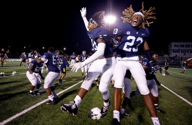 East Lansing players, including Jeff Bridges, right, and Artchez Hall, celebrate after their win over DeWitt, Friday, Sept. 16, 2022, in East Lansing, Mich.  East Lansing won 36-30.