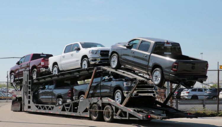 A car hauler transports Dodge Ram pick-up trucks to a holding lot across from the FCA Jefferson North Assembly Plant in De...