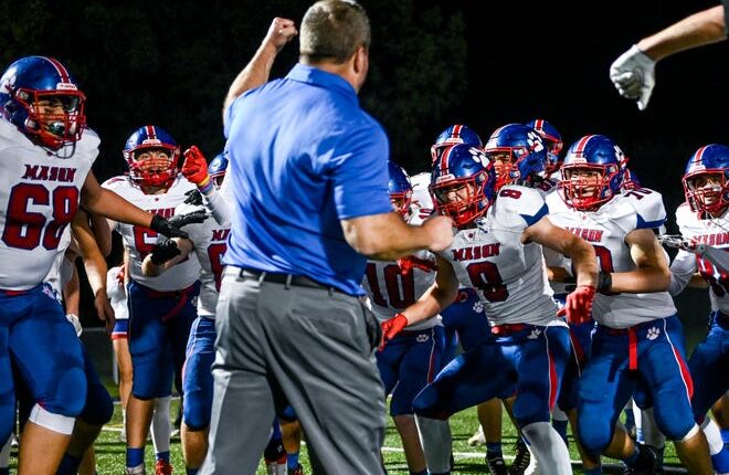 Mason celebrates with head coach Gary Houghton after beating Haslett on Friday, Sept. 23, 2022, at Haslett High School.