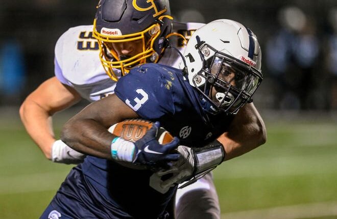 East Lansing's Kanye Jackson, right, runs for a gain as Grand Ledge's Teddy Williams makes the tackle during the third quarter on Friday, Oct.  21, 2022, at East Lansing High School.