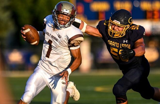 Holt's Seneca Moore, left, runs for a gain as Grand Ledge's Ryan Beattie closes in during the second quarter on Friday, Sept. 9, 2022, at Grand Ledge High School.