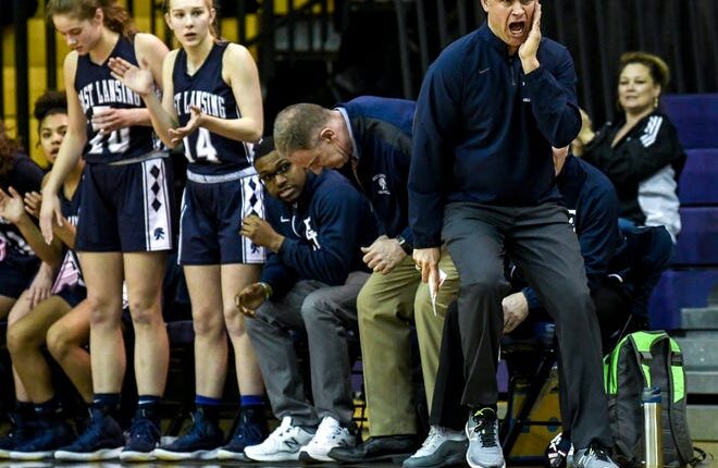 East Lansing's head coach Rob Smith, right, calls out to the team during the first quarter on Monday, March 11, 2019, at Caledonia High School.
